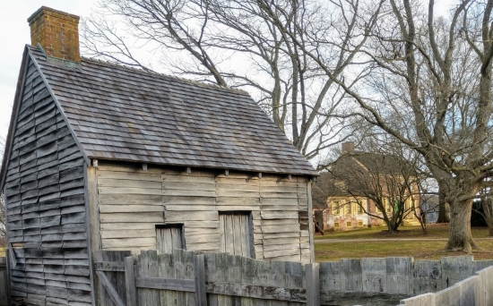 The log’d dwelling at the John Dickinson Plantation is a replica of the type of housing inhabited by people who were enslaved at the plantation, as well as the property's tenants and indentured servants. The site’s mansion house is in the background.