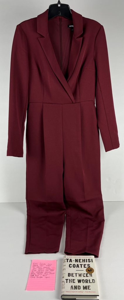 A collection of objects from Senator Marie Pinkney includes a burgundy suit that she wore when she was sworn in, a piece of paper with a note of inspiring figures and a book titled "Between the World and Me."