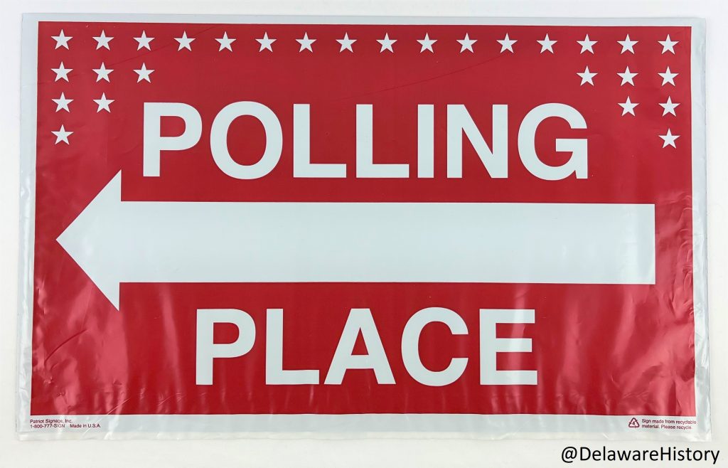 A red sign with an arrow to denote a polling place.