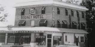 This image shows a black and white photograph of the Rodney Hotel that the last owners had at the property. 