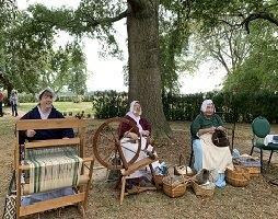 The Thistledown Fiber Arts Guild is shown here in historic costuming doing craft work that includes spinning, weaving, knitting and other fabric arts.