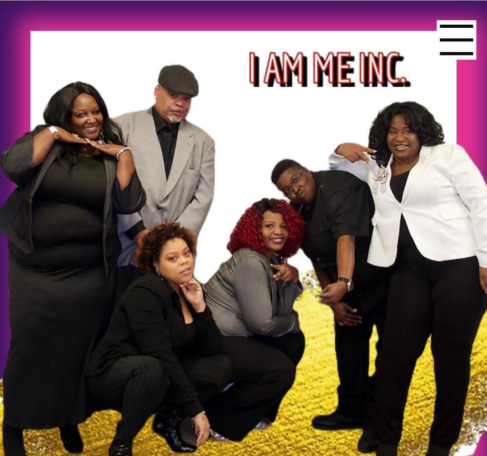 Six Black people smile and pose for the camera. The graphic for I Am Me Inc. appears at the top. 