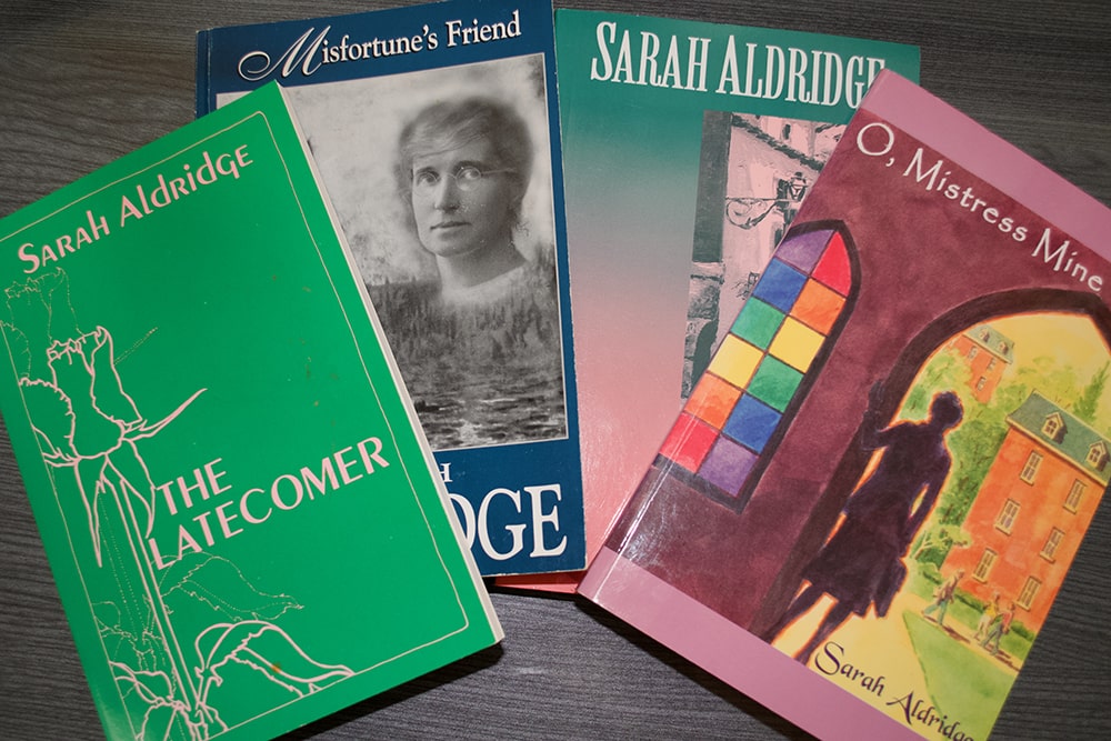 4 covers of paperback novels by Sarah Aldridge are seen.