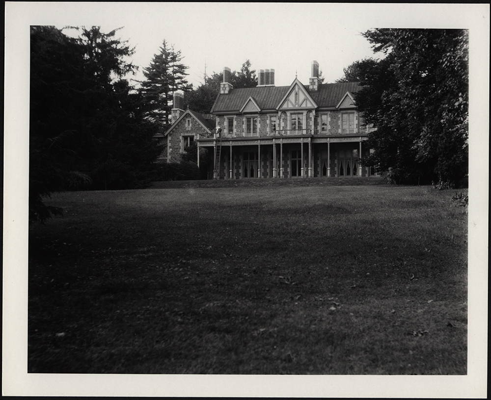 A Gothic Revival mansion seen from across a grass lawn.