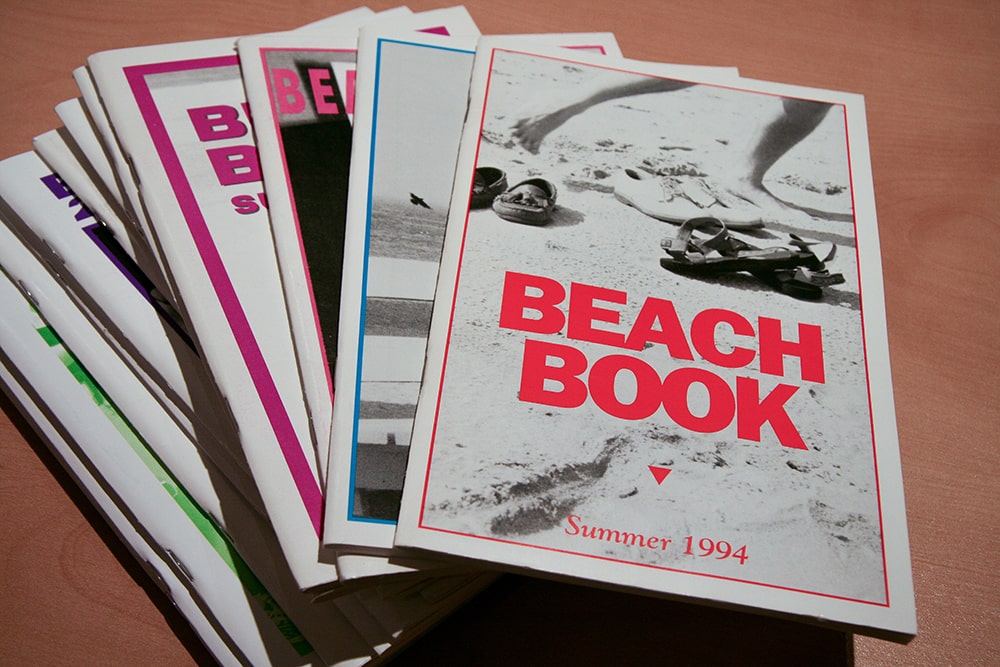 A stack of booklets. The book on the top says “BEACH BOOK Summer 1994.”