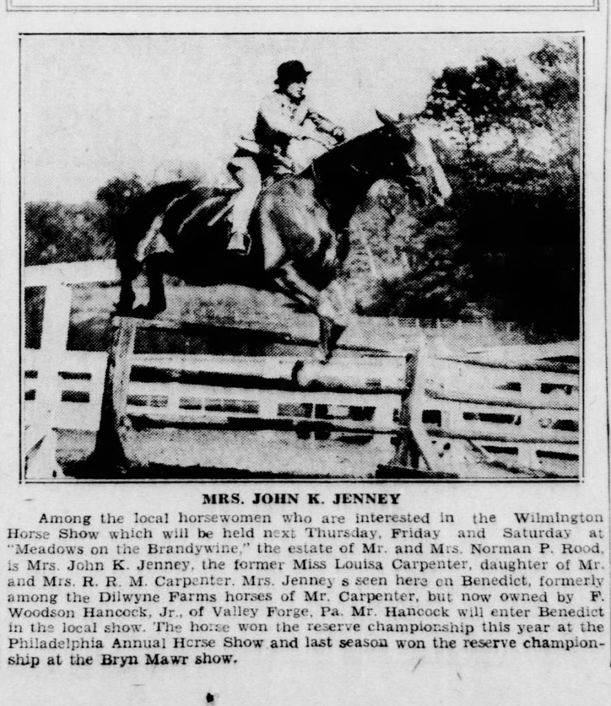 A black and white photograph of a woman on a horse performing a jump.