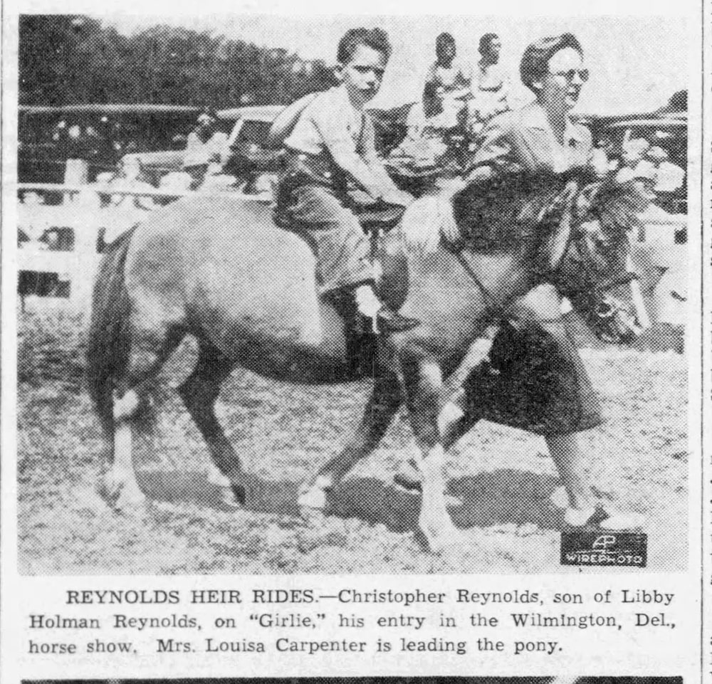 A white woman leads a pony who is carrying a small white boy on its saddle.