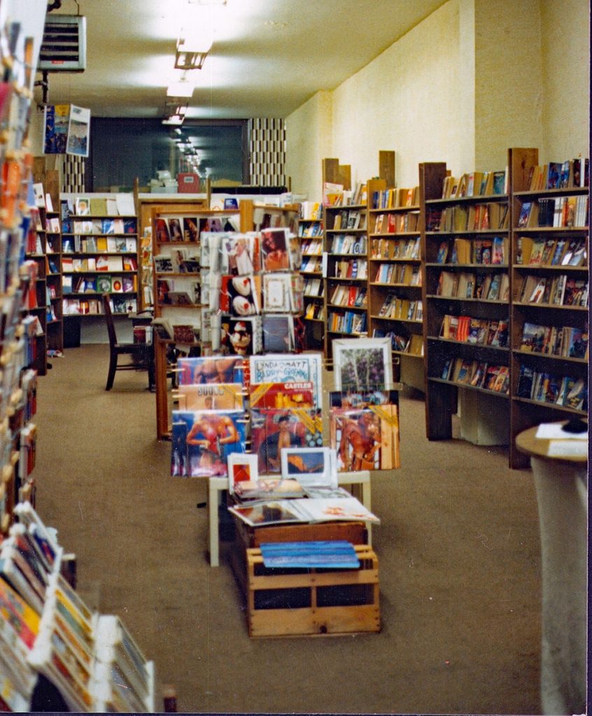 A room with bookshelves lining all of the walls with a central book display.