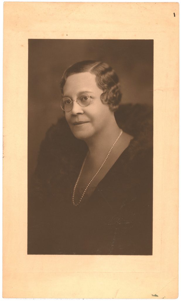 A portrait of an older light-skinned woman with her hair parted to the side in a flapper style.