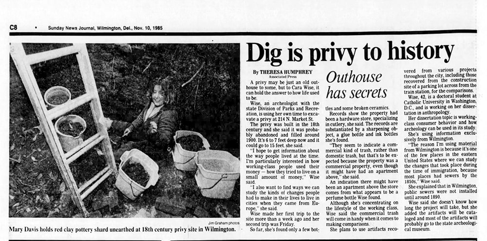A newspaper article with the title “Dig is privy to history,” appears with a photo of a woman archaeologist.