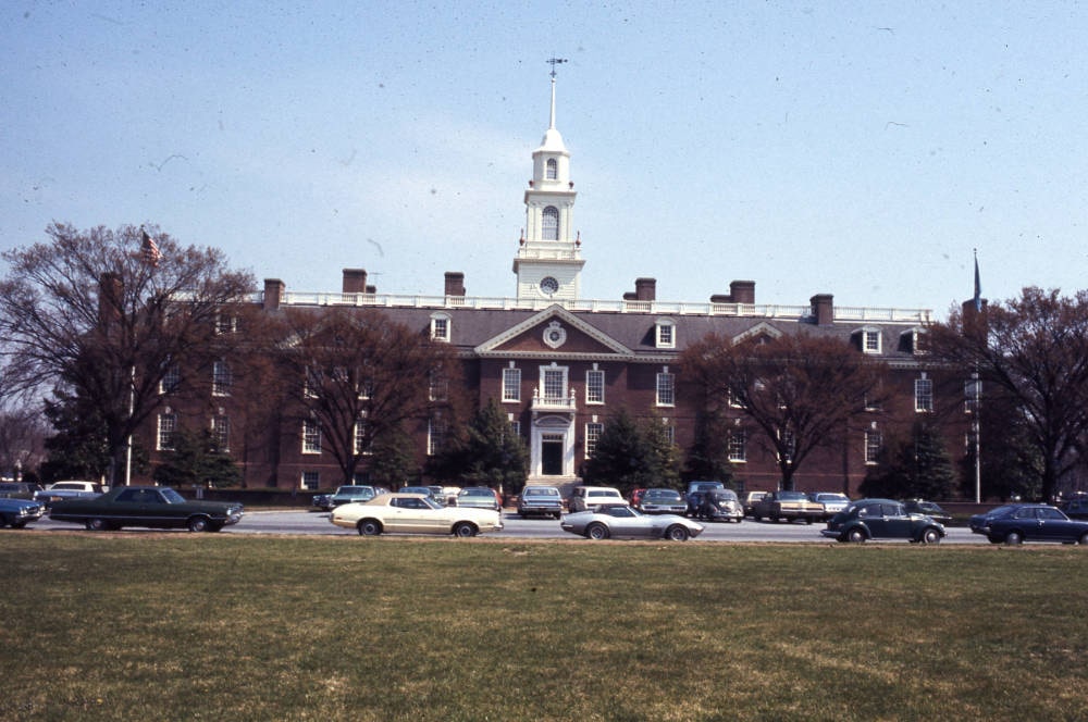 A colonial revival legislative building seen from the green.