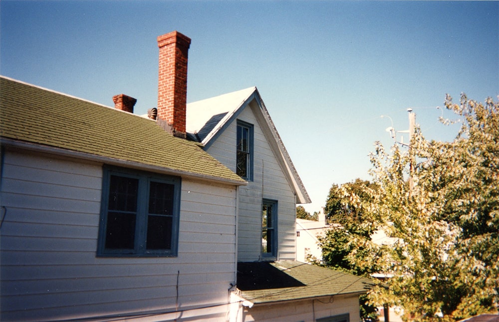 Two houses with two different rooflines are seen pushed together to form one larger house.