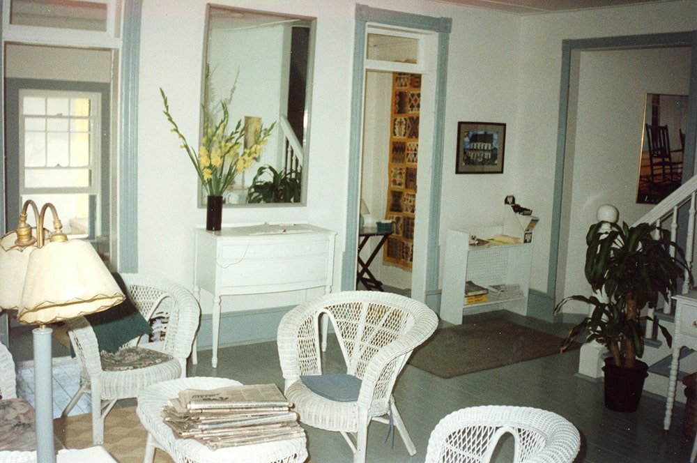 An interior view of a room with white walls and wicker furniture.