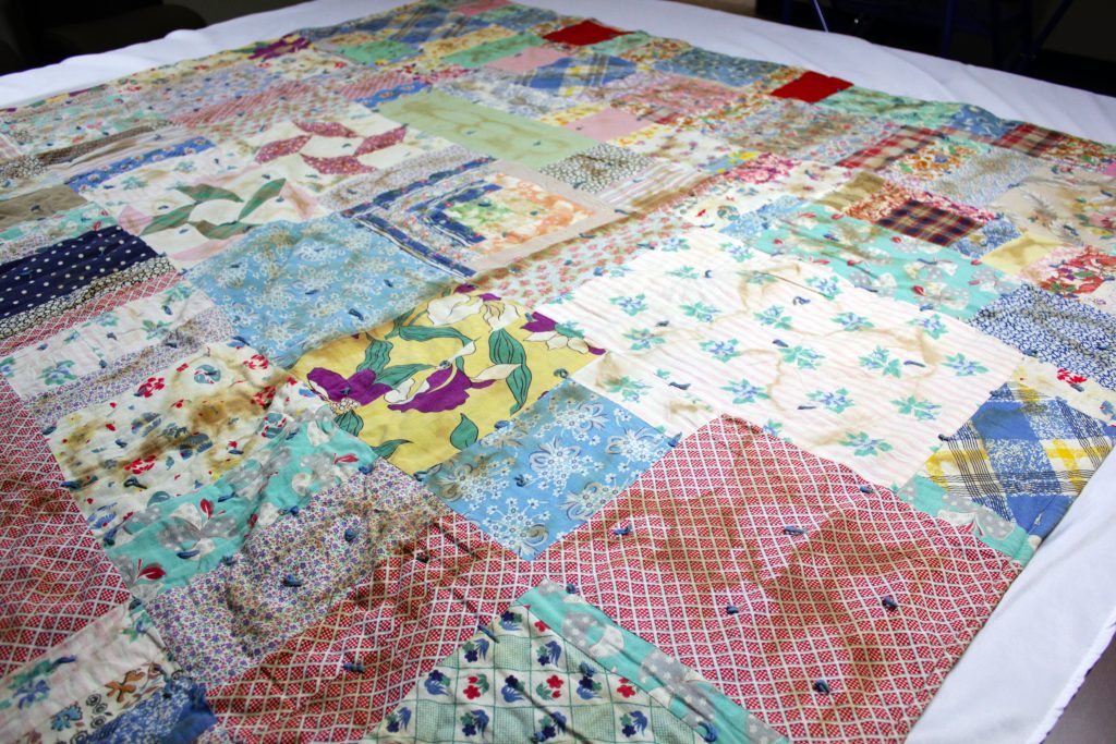 Vibrant multicolor quilt made of various fabrics in floral and checkered patterns