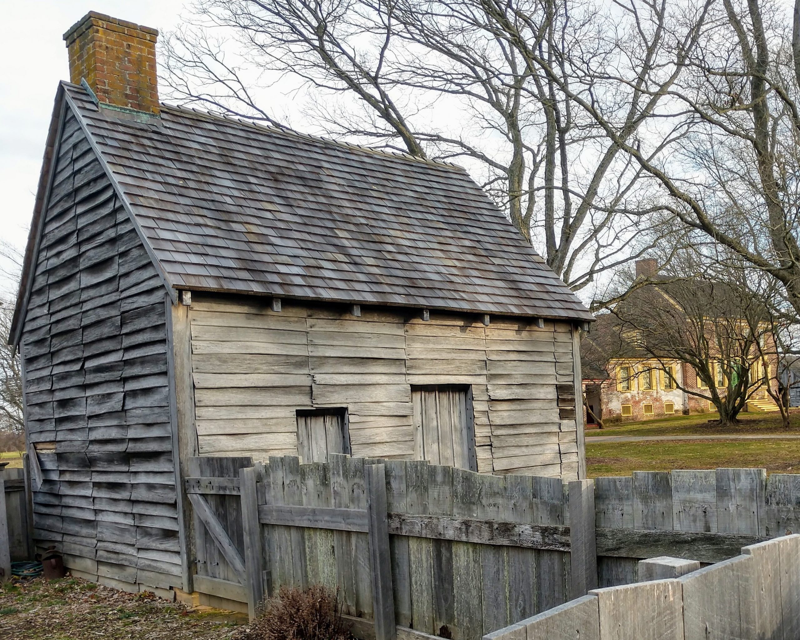 Log’d dwelling at the John Dickinson Plantation. The building is a reconstruction of the type of housing inhabited by the enslaved people at the plantation as well as its tenants and indentured servants. The site’s mansion house is in the background.