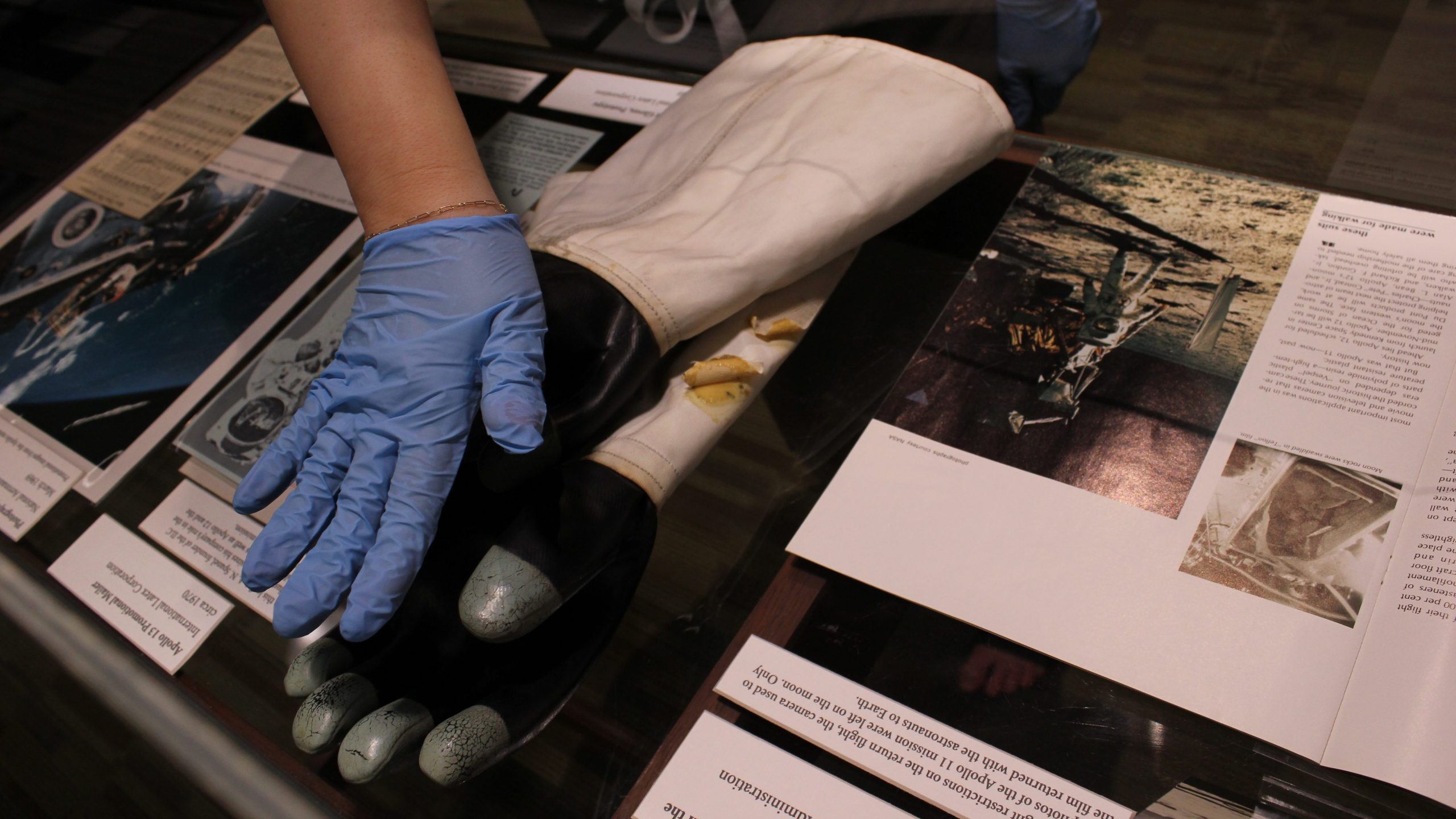 The Apollo Exhibit at the Dover Library being adjusted by an HCA curator.