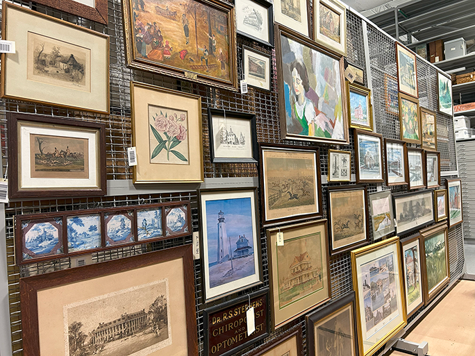 Hanging painting shelf featuring paintings from various historic Delaware artists