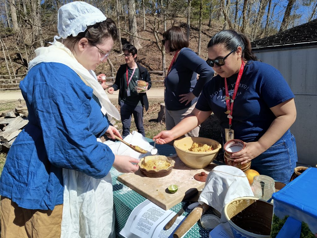 museum staff filling pie shells with apple mixture
