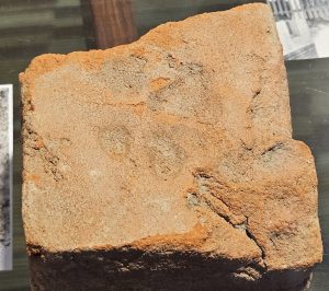 part of an 18th-century brick, found at an archaeological site with a small dog paw print in the brick.