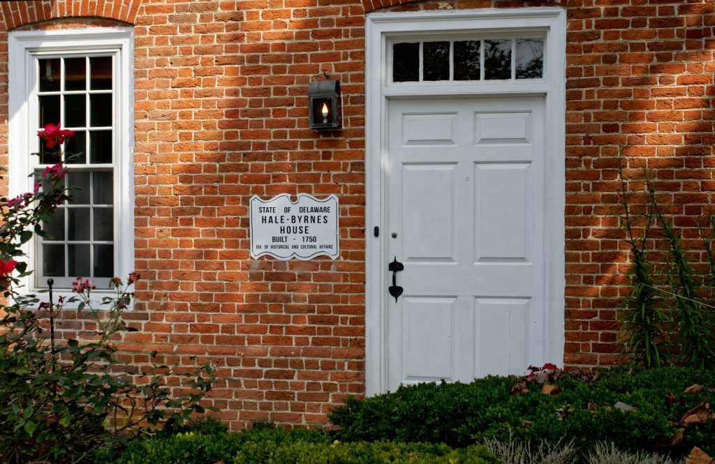 The front door of Hale-Byrnes house, a white door against a brick wall.
