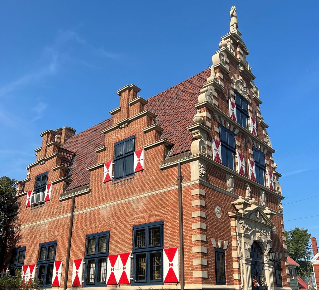 The Zwaanendael Museum on a sunny day, against a blue sky. 