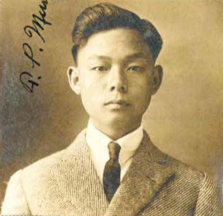 Asian American in a suit and tie gazing into the camera.