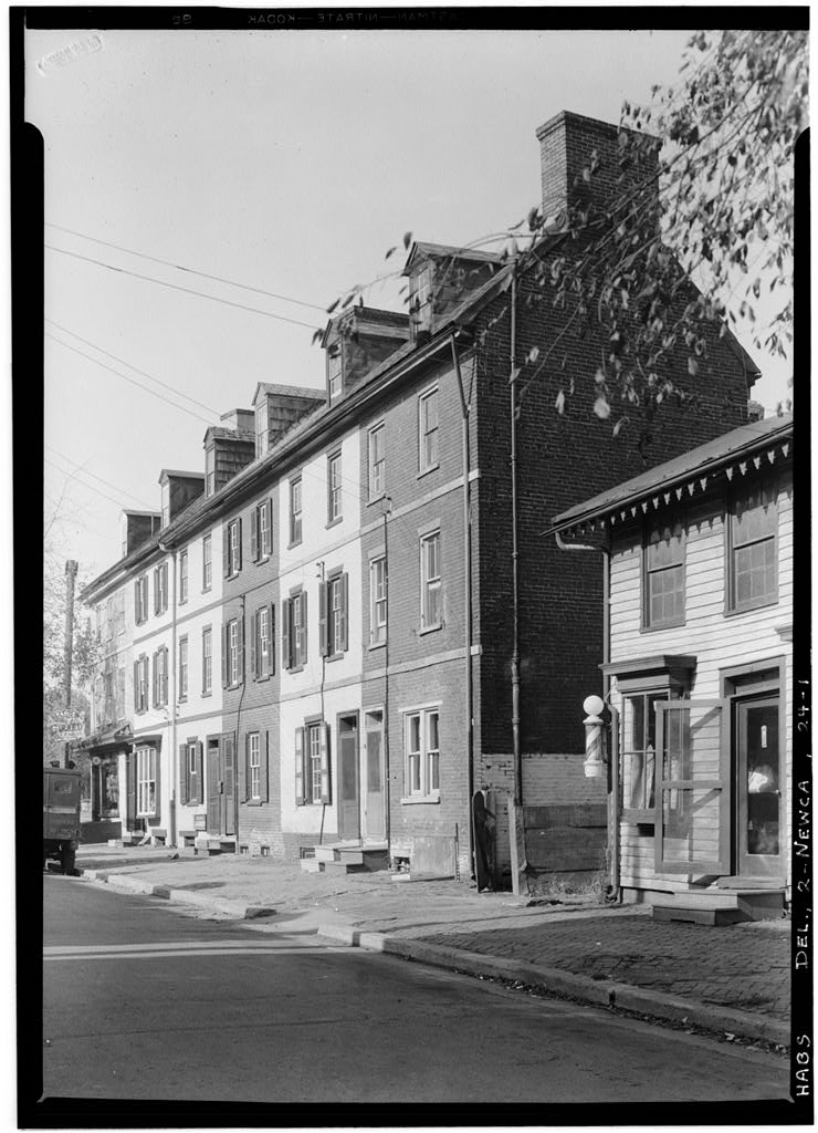 Exterior of attached buildings with dormers near a standalone barber shop.