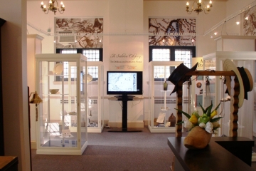 A wide view of the entrance to the DeBraak ship exhibit showing objects in several display cases