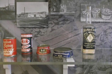 Food and drink containers in front of black and white photographs as part of the Delaware Railroads exhibit